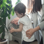 Mother and son water a houseplant 
