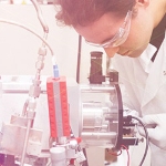 a scientist in a lab looking through a microscope
